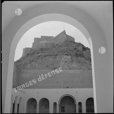 [Vue du fort de Santa Cruz depuis l'encadrement d'une porte de la basilique Notre Dame à Oran.]