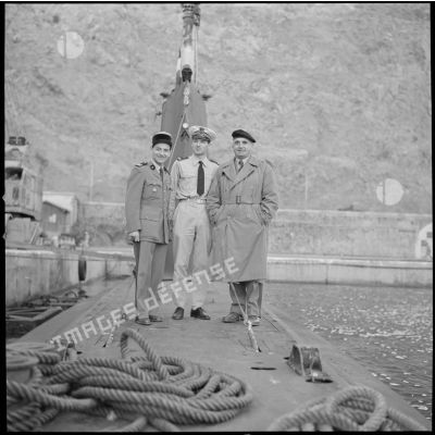 [Commandant, officier de la Marine et aumônier militaire posant dans le port d'Oran.]