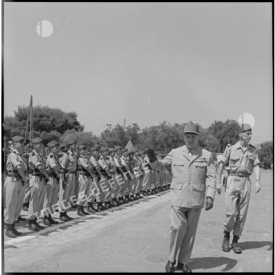 [Général de division Katz, suivi du commandant Benoist d'Azy, passant en revue les troupes du 2e régiment de zouaves (RZ).]