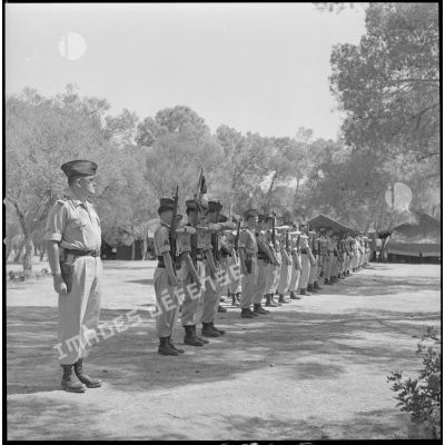 [Soldats de la 5e compagnie du 2e régiment de zouaves (RZ) présentant les armes au campement de la forêt Moulay Ismaïl.]