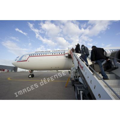 Embarquement de ressortissants évacués par la passerelle de l'Airbus A340 de l'escadron de transport 3/60 Esterel sur l'aéroport de Tripoli (Libye), en présence d'un agent du ministère des Affaires étrangères.