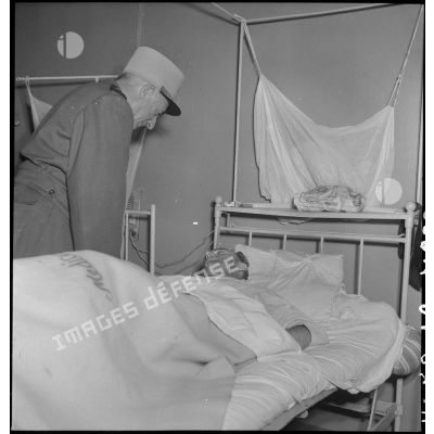 Le général de Linarès au-dessus du lit d'un soldat alité à l'hôpital Lanessan à Hanoï.