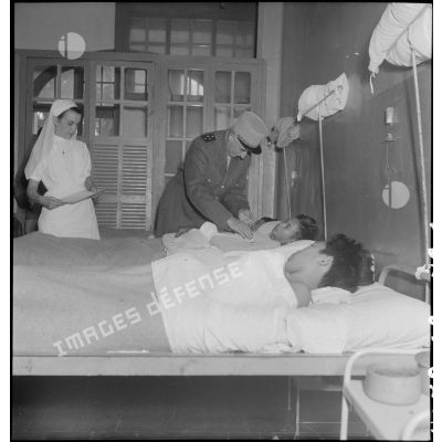 Le général de Linarès au dessus du lit de soldats vietnamiens à l'hôpital Lanessan à Hanoï.