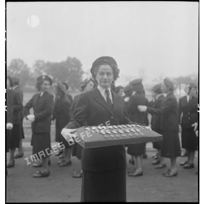 Une militaire portant le coussin des décorations lors de la prise d'armes du personnel féminin de l'armée de Terre au stade Mangin.