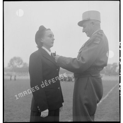 Le général de Linarès décore une infirmière d'une antenne chirurgicale, lors de la prise d'armes du PFAT(personnel féminin de l'armée de Terre) au stade Mangin.