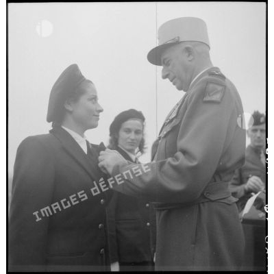 Le général de Linarès décore une femme lors de la prise d'armes du PFAT(personnel féminin de l'armée de Terre) au stade Mangin.