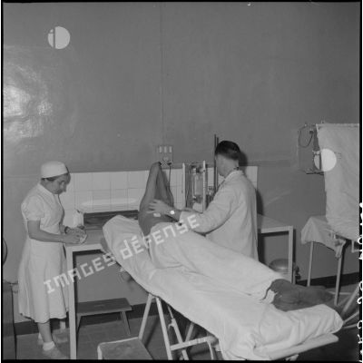 Un médecin soigne un homme à l'hôpital militaire Lanessan.