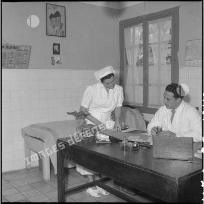 Une infirmière et un médecin dans cabinet médical de l'hôpital militaire Lanessan.