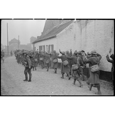 A Thulin (Belgique), entre Mons et Valenciennes, le village vient d'être capturé, un groupe de prisonniers français dans la rue Brouta.