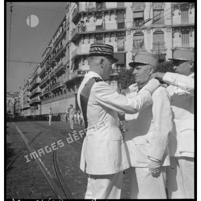 Un général de corps d'armée décore des sous-officiers lors de la cérémonie du 14 juillet au Plateau des Glières à Alger.