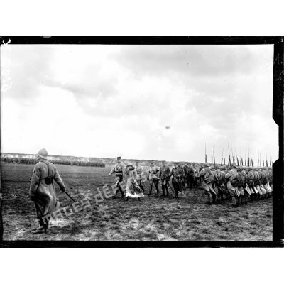 La reine des Belges, accompagnée du général Anthoine, passe sur le front des troupes de la 1re DI sur le champ d'aviation de Saint-Pol-sur-Mer. [légende d'origine]