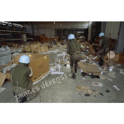 Des marsouins du 2e RIMa pénètrent dans un hangar dévasté de l'aéroport de Sarajevo.