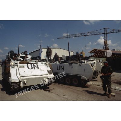 Militaires canadiens autour de deux blindés chenillés M-113 assurant la protection de l'aéroport de Sarajevo.