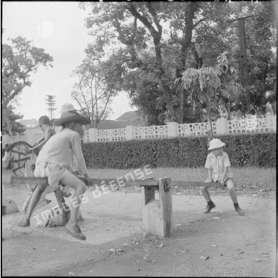 Enfants sur une balançoire au jardin d'enfants vietnamiens à Hanoï.