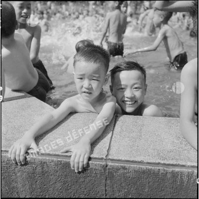 Deux jeunes enfants se baignent dans la piscine du jardin d'enfants vietnamiens à Hanoï.