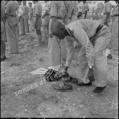 Un officier africain musulman des troupes coloniales se déchausse pour se laver les mains et effectuer ses prières, avant l'embarquement pour le pèlerinage à la Mecque.