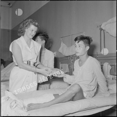 Madame Hinh remet un paquet à un soldat vietnamien à l'hôpital militaire Lanessan.