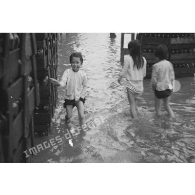 Enfants dans une rue inondée.