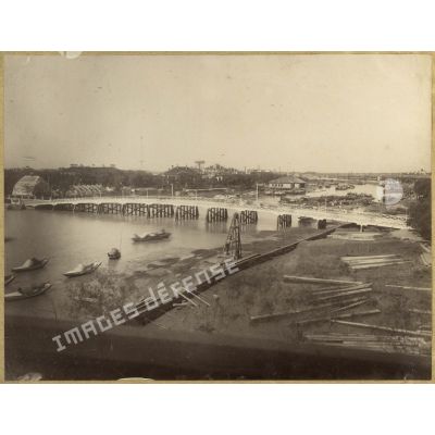 [Chine, 1887-1891. Panorama d'une ville traversée par une rivière].