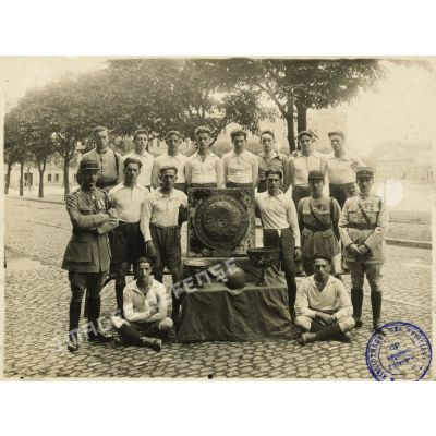 Portrait de groupe des sportifs du 158e régiment d'infanterie (RI) posant autour de leur coupe à Strasbourg.