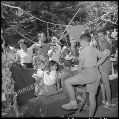 Des enfants autour d'un stand du jeu de pêche à la ligne lors de la kermesse de la colonie de vacances de Chréa.