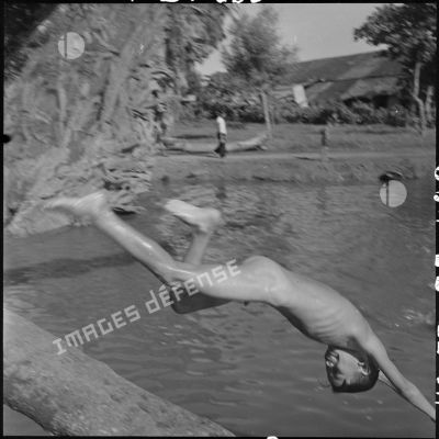 Jeune garçon plongeant dans un point d'eau.