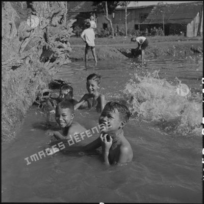 Groupe d'enfant se baigant dans un point d'eau.