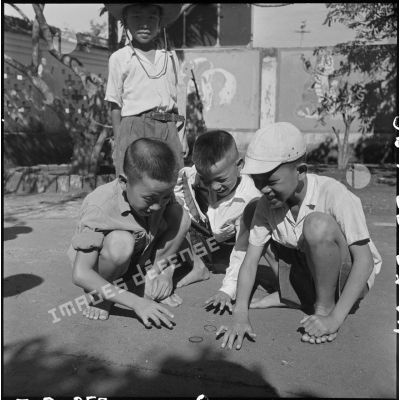 Jeunes garçons jouant avec des élastiqes.