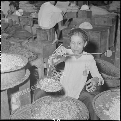 Une femme pèse des pousses de soja au grand marché d'Hanoï.
