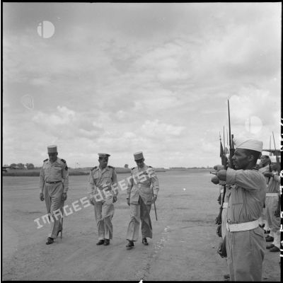 Le général Navarre, commandant en chef en Indochine, le général Cogny, commandant en chef des FTNV (forces terrestres du Nord-Vietnam), et le colonel Duranton, commandant la base de Bach Mai, passent les troupes en revue.