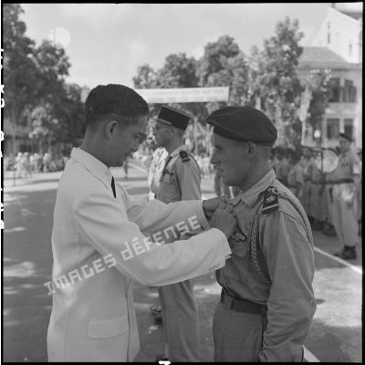M. Phan Huy Quat, ministre de la Défense, remet la médaille du Mérite militaire vietnamien à un adjudant  du 8e BPC (bataillon de parachutistes coloniaux) ayant participé à l'opération Hirondelle.