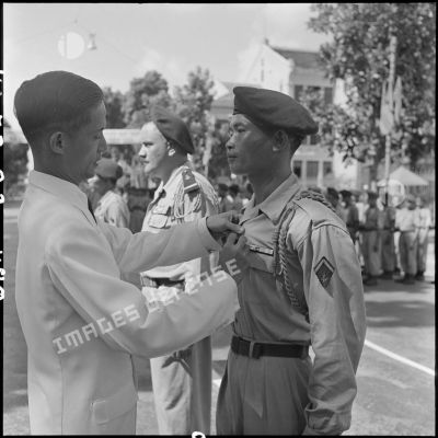 M. Phan Huy Quat, ministre de la Défense, remet la Croix de la vaillance à l'Ordre de l'Armée à un sergent du 6e BPC (bataillon de parachutistes coloniaux) ayant participé à l'opération Hirondelle.