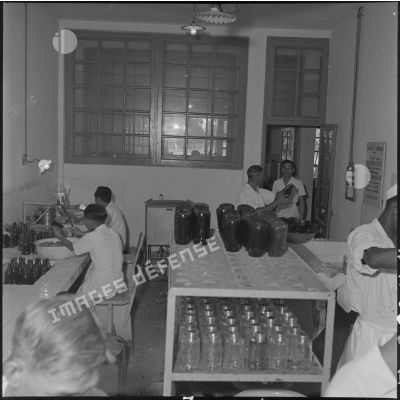 Personnel au travail dans la salle de lavage des flacons de sang de l'ORT (Organisme de transfusion) d'Hanoï.