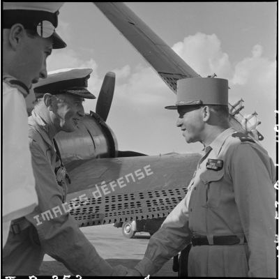 Le général Lambe (à gauche), commandant en chef des forces navales britanniques dans le sud-est asiatique, et le général Masson (à droite), adjoint au commandant en chef des FTNV (forces terrestres du Nord-Vietnam), se serrent la main sur un des aérodromes d'Hanoï.