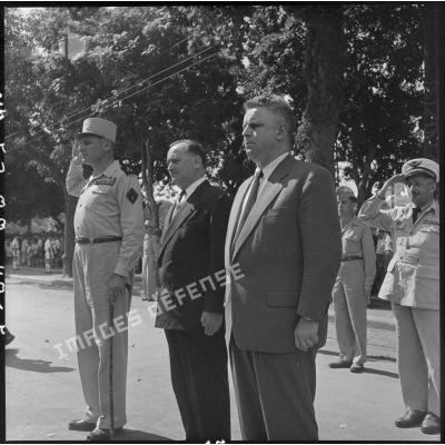 Le général Cogny, M. Maurice Dejean et M. Marc Jacquet pendant les hymnes nationaux.