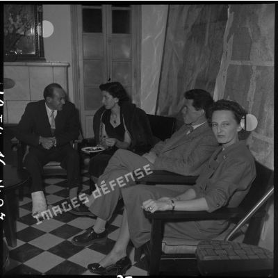 Les photographes du Service presse information (SPI) Paul Corcuff et  Georges Liron  en compagnie de deux femmes au cours d'une réception au camp de presse d'Hanoï.