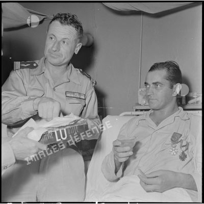 Un toast est porté à l'adjudant-chef Bartier après sa décoration de la Légion d'honneur et de la Croix de guerre des TOE par le général Dechaux à l'hôpital Lanessan.