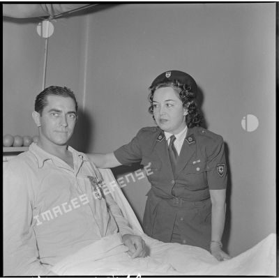 L'adjudant-chef Bartier pose avec un personnel de la Croix-Rouge française (CRF) après sa décoration de la Légion d'honneur et de la Croix de guerre des TOE par le général Dechaux à l'hôpital Lanessan.
