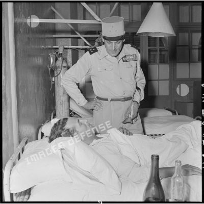 Le général Cogny, commandant en chef des FTNV (forces terrestres du Nord-Vietnam), au chevet d'un blessé rapatrié à l'hôpital militaire Lanessan.