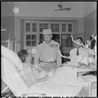 Le général Cogny, commandant en chef des FTNV (forces terrestres du Nord-Vietnam), s'entretient avec un soldat blessé à Diên Biên Phu et rapatrié à l'hôpital militaire Lanessan.
