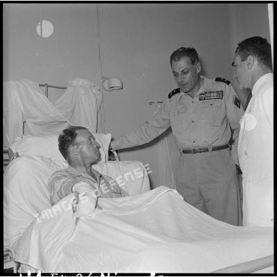 Le général Cogny, commandant en chef des FTNV (forces terrestres du Nord-Vietnam), s'entretient avec un soldat blessé à Diên Biên Phu et rapatrié à l'hôpital militaire Lanessan.