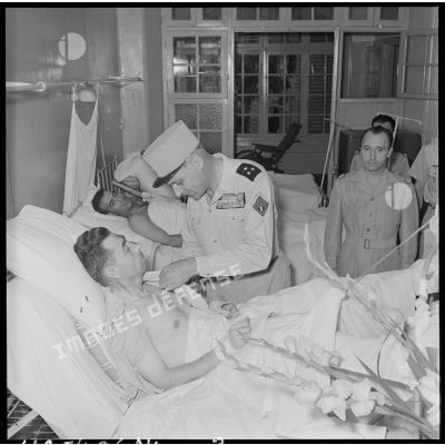 Le général Cogny, commandant en chef des FTNV (forces terrestres du Nord-Vietnam), décore un soldat blessé à Diên Biên Phu et  rapatrié à l'hôpital militaire Lanessan.