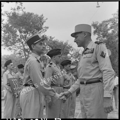 Le général Cogny, commandant en chef des FTNV (forces terrestres du Nord-Vietnam), félicite un capitaine décoré de la Légion d'honneur à l'occasion de la Fête de Jeanne d'Arc.
