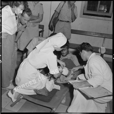 Ce soldat blessé, évacué de Diên Biên Phu, reçoit des soins dans la salle de triage de l'hôpital militaire Lanessan d'Hanoï.