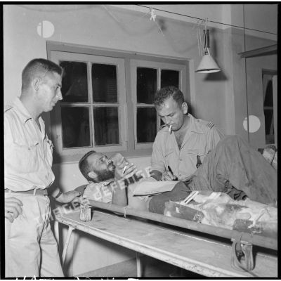 Un soldat blessé, évacué de Diên Biên Phu et hospitalisé à l'hôpital militaire Lanessan d'Hanoï, s'entretient avec un officier.