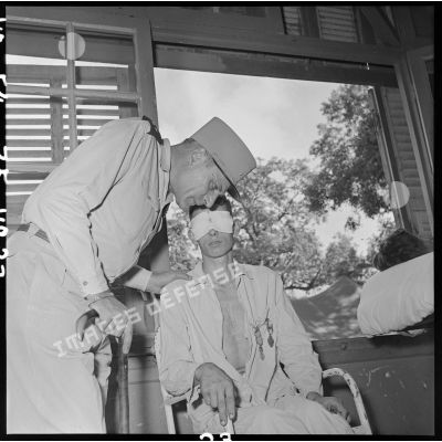 Le général Cogny, commandant en chef des FTNV (forces terrestres du Nord-Vietnam), s'entretient avec un soldat blessé à Diên Biên Phu et soigné à l'hôpital militaire Lanessan d'Hanoï.