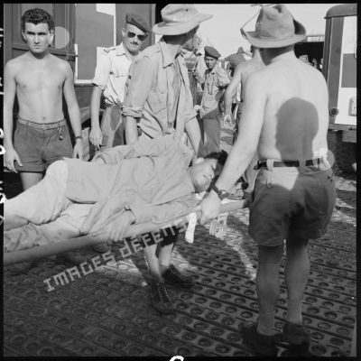 Sur l'un des aérodromes d'Hanoï, un blessé vietnamien est transporté à bord d'une ambulance.