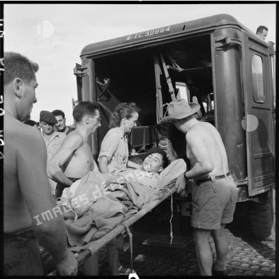 Sur l'un des aérodromes d'Hanoï, un blessé vietnamien est transporté à bord d'une ambulance.