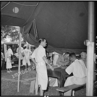 Personnel médical et administratif sous une tente de triage installée à l'hôpital militaire Lanessan.