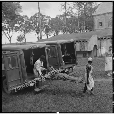 Les brancardiers transportent les derniers blessés évacués de Diên Biên Phu dans la tente de triage.